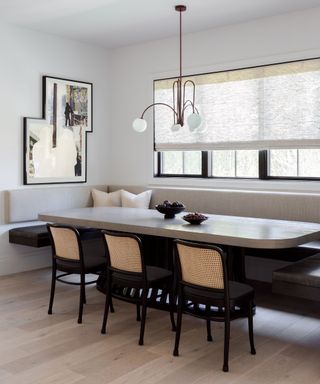 breakfast nook with banquette seat and long oval table and black chairs