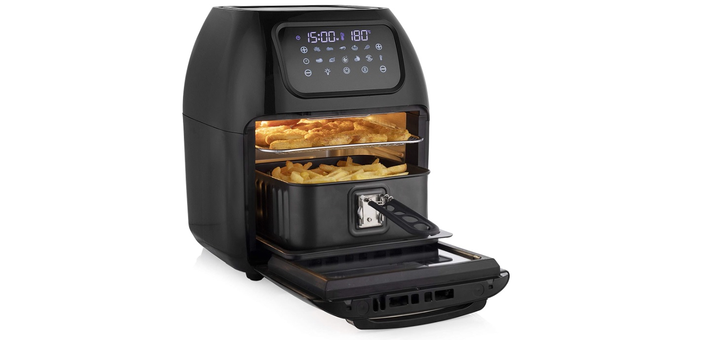 En svart Tristar Multi Crispy Fryer Oven visas upp mot en vit bakgrund, med pommes frites i den nedre behållaren och nuggets på den övre plåten.