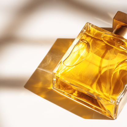 Unlikeable fragrance: glass bottle Perfume in a glass transparent bottle with caustic Light effect on white beige