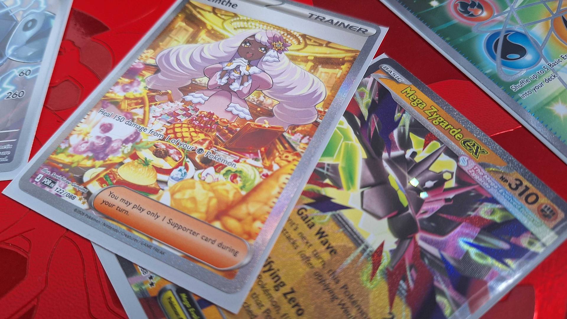 Pokemon cards lying on a red surface