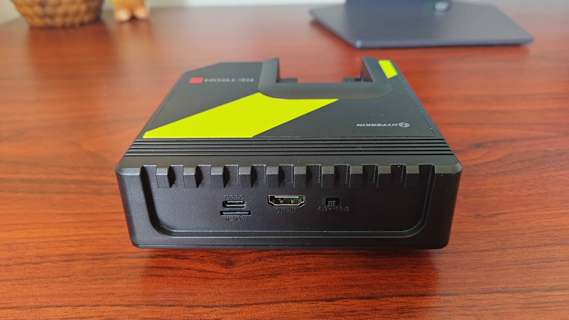 Hyperkin Retron GX with back ports facing forward on woodgrain desk.