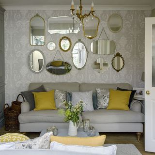 living room with grey sofa and wall mirror
