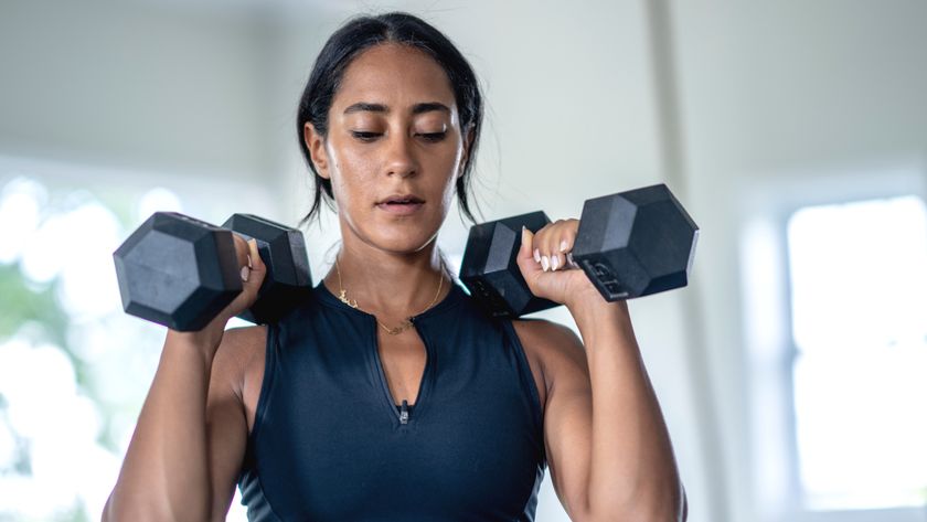 a photo of a woman lifting dumbbells above her shoulders