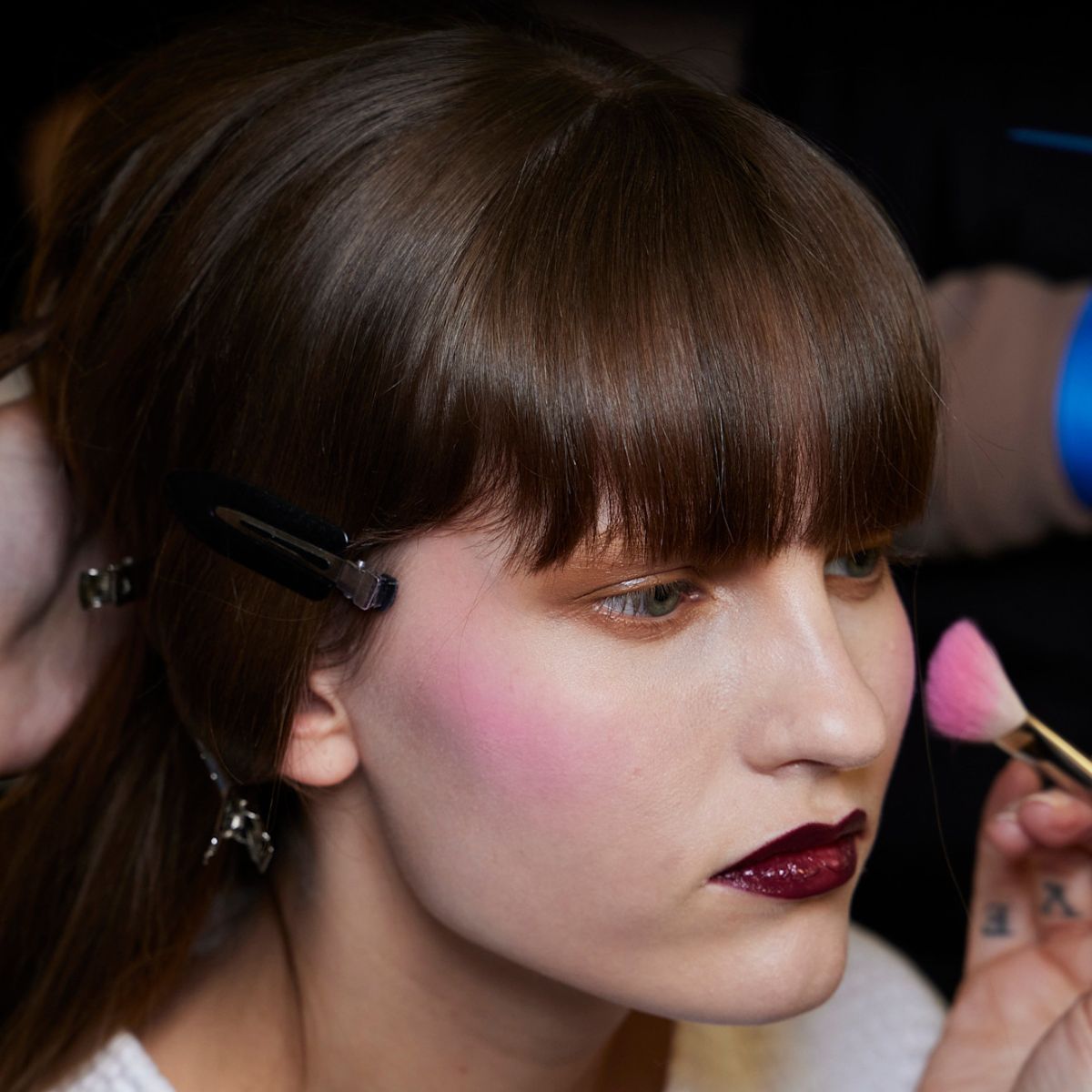 model backstage at fashion week with pastel pink blush