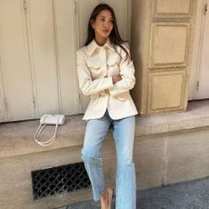 Fashion influencer wearing jeans, a white jacket, and a white Chanel bag