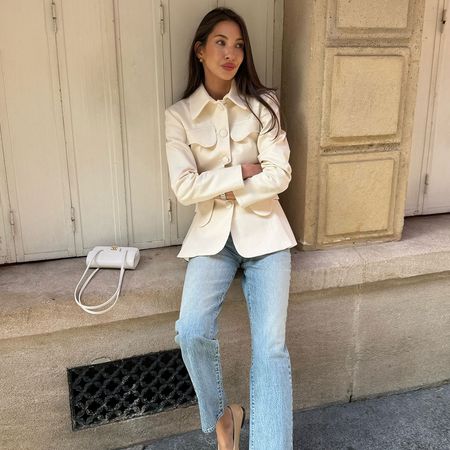 Fashion influencer wearing jeans, a white jacket, and a white Chanel bag