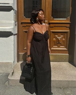 @nnennaechem wearing a black dress and mini bag