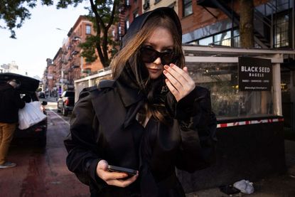 Anna Sorokin walks on the street wearing all black.