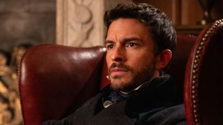 Jonathan Bailey sits in a chair