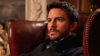 Jonathan Bailey sits in a chair