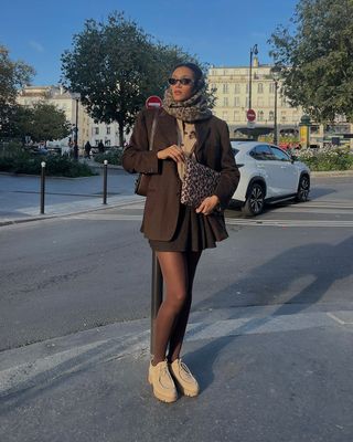 @lenafarl wearing a brown blazer and mini skirt with leopard print accessories