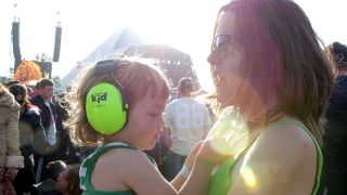A parent holds their child in a festival crowd
