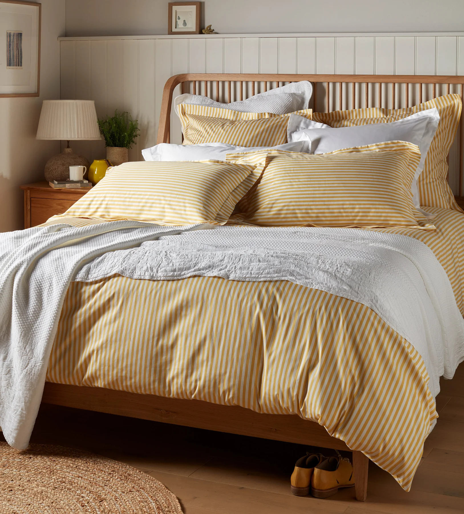 striped yellow bedding on a wood bed