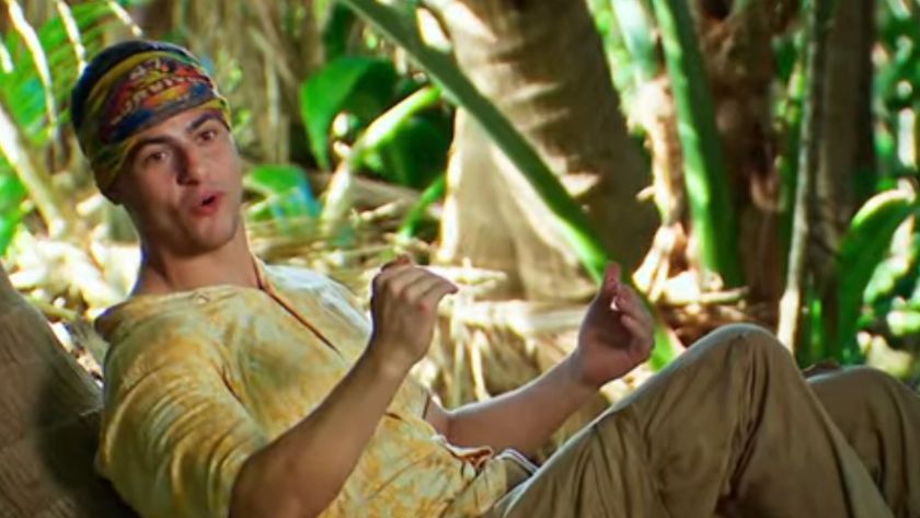Sam lays against a tree and talks about strategy on Survivor.