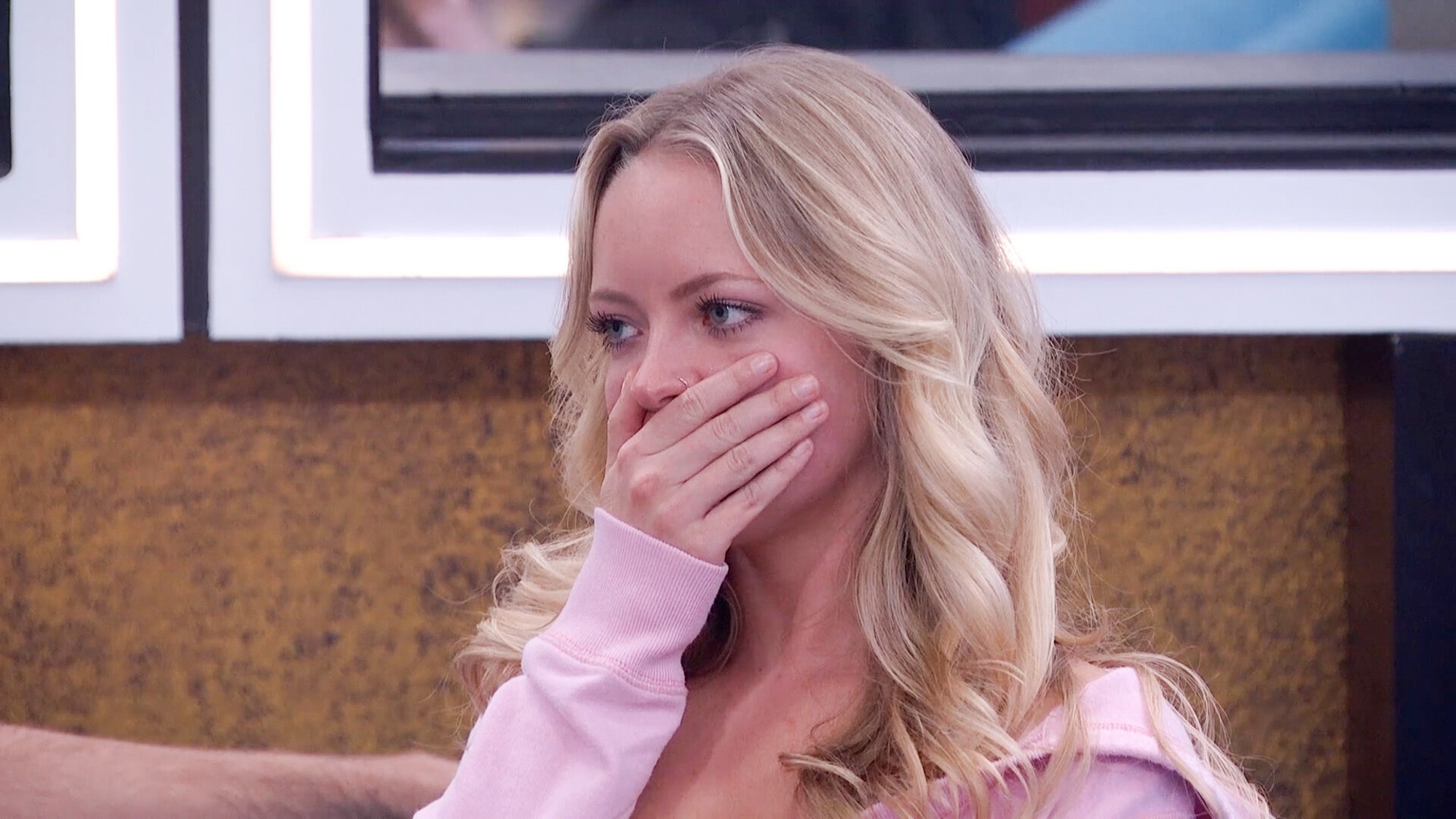 Melody covering her mouth with her hands.