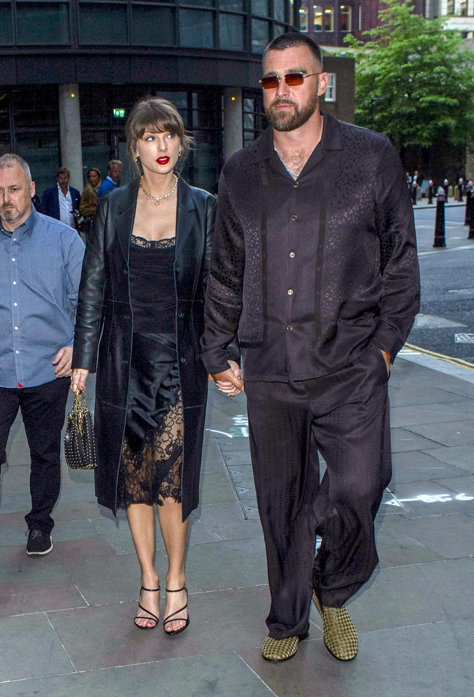 Taylor Swift wears a lacy silk skirt and matching top with a long leather trench coat and Celine sandals for a London date with Travis Kelce