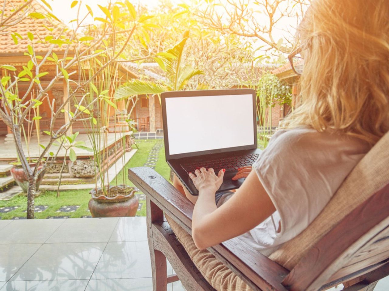 Person Using A Laptop Infront Of A Garden