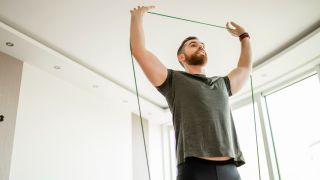 Man performs overhead press with resistance band