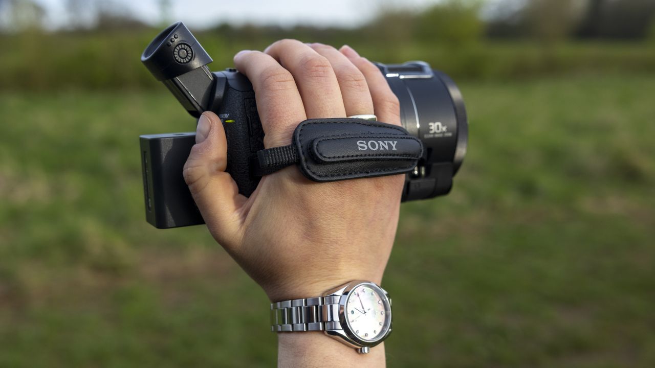 The Sony FDR-AX53 camcorder in a photographer's hand