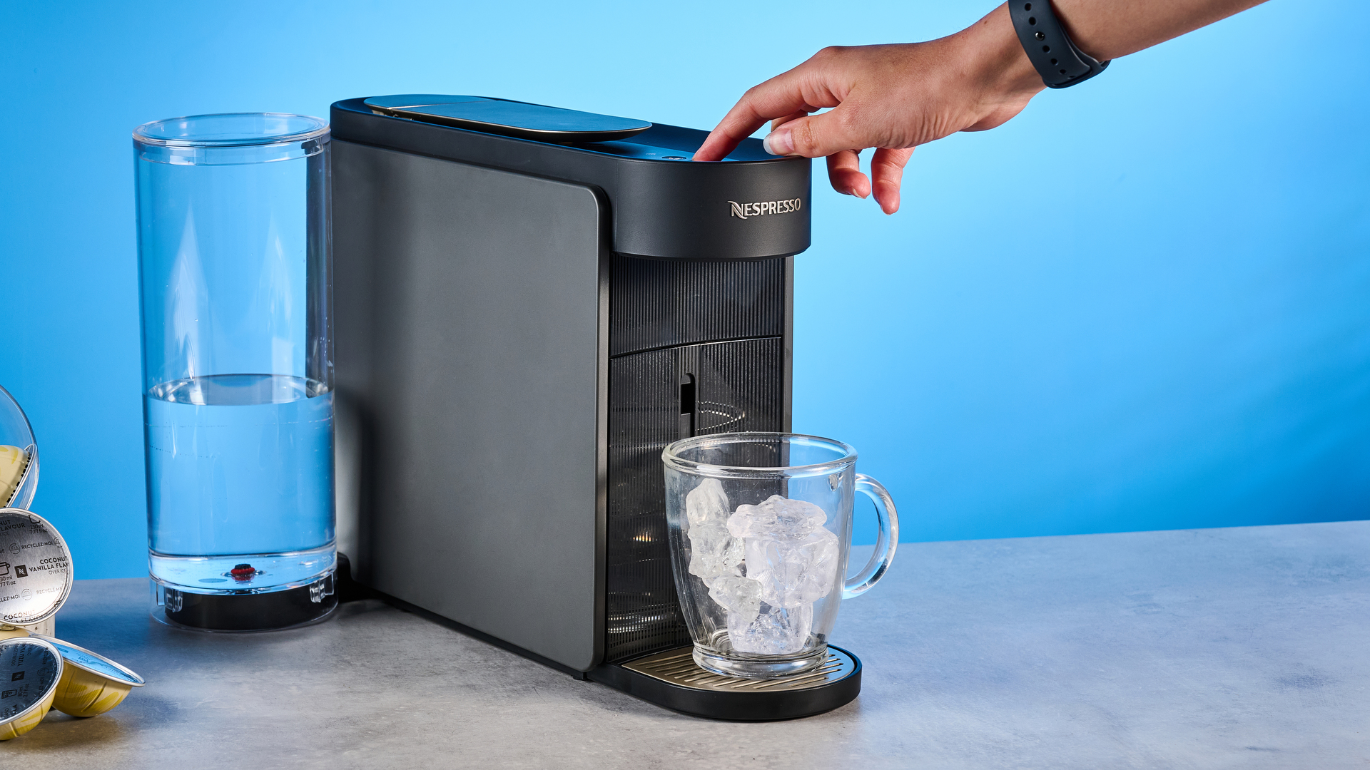 the nespresso vertuo up machine photographed against a blue background