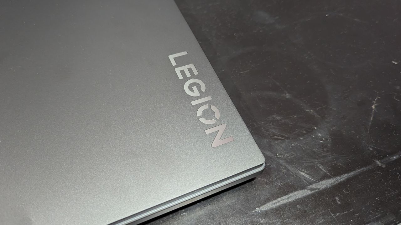 Lenovo Legion Pro 5i closed on a black desk, highlighting the gray lid and the Legion logo in the corner.