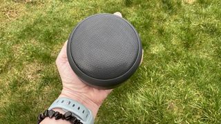 Someone holding the Nokia Portable Wireless Speaker 2 over some grass.