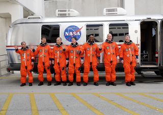 The STS-122 mission crew pauses alongside the Astrovan to wave farewell to onlookers before heading for Launch Pad 39A for the launch of space shuttle Atlantis on the STS-122 mission. From left are Mission Specialists Leopold Eyharts, Stanley Love, Hans S