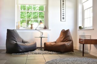Faux leather bean bags from Cuckooland on a textured rug in a living room with soft lighting