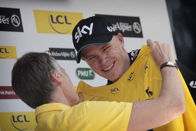 Chris Froome smiles as he pulls on the yellow jersey