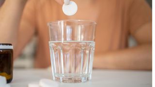 denture tablet being put in a glass