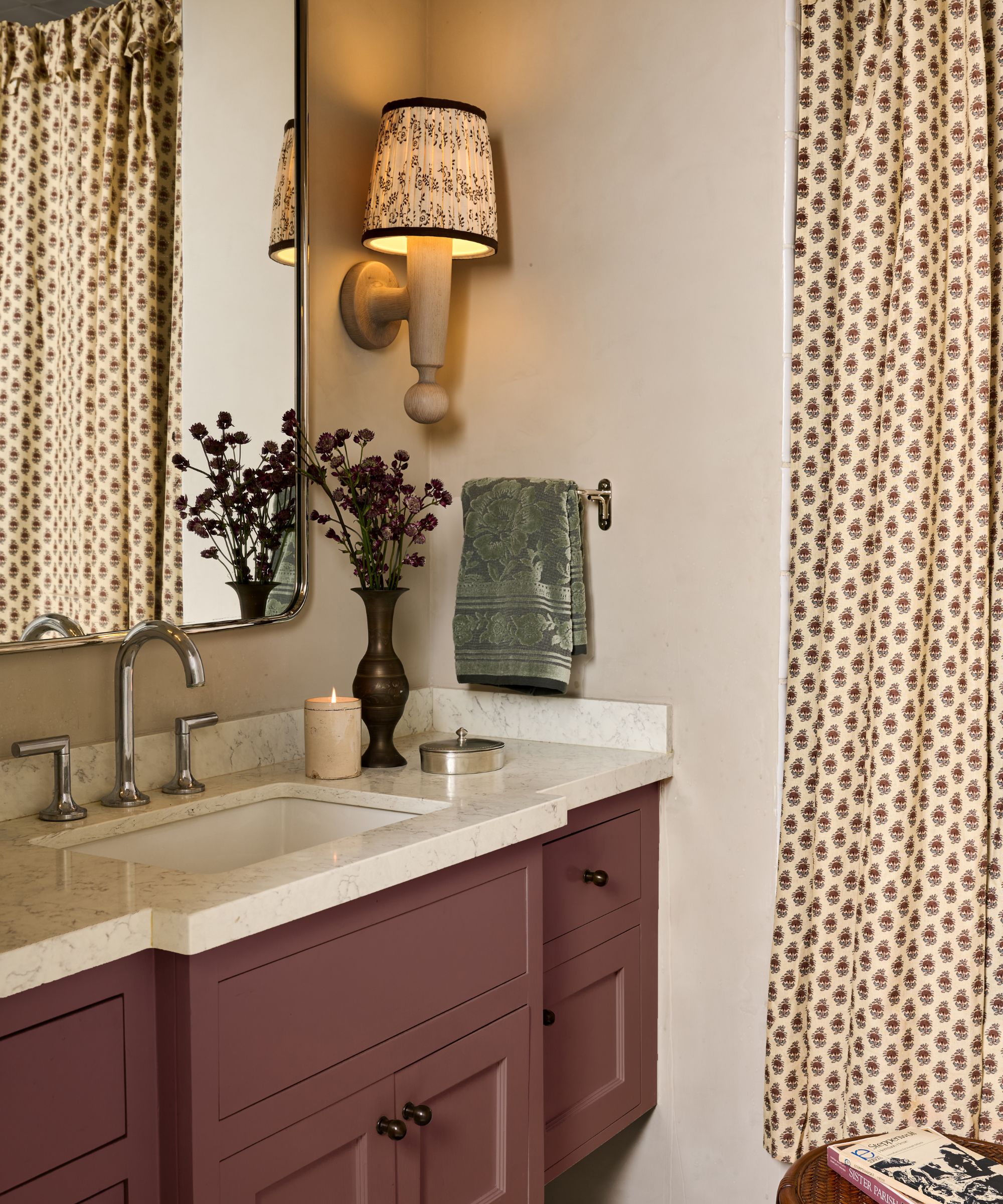 a neutral small bathroom with berry red pink vanity and block print floral shower curtain