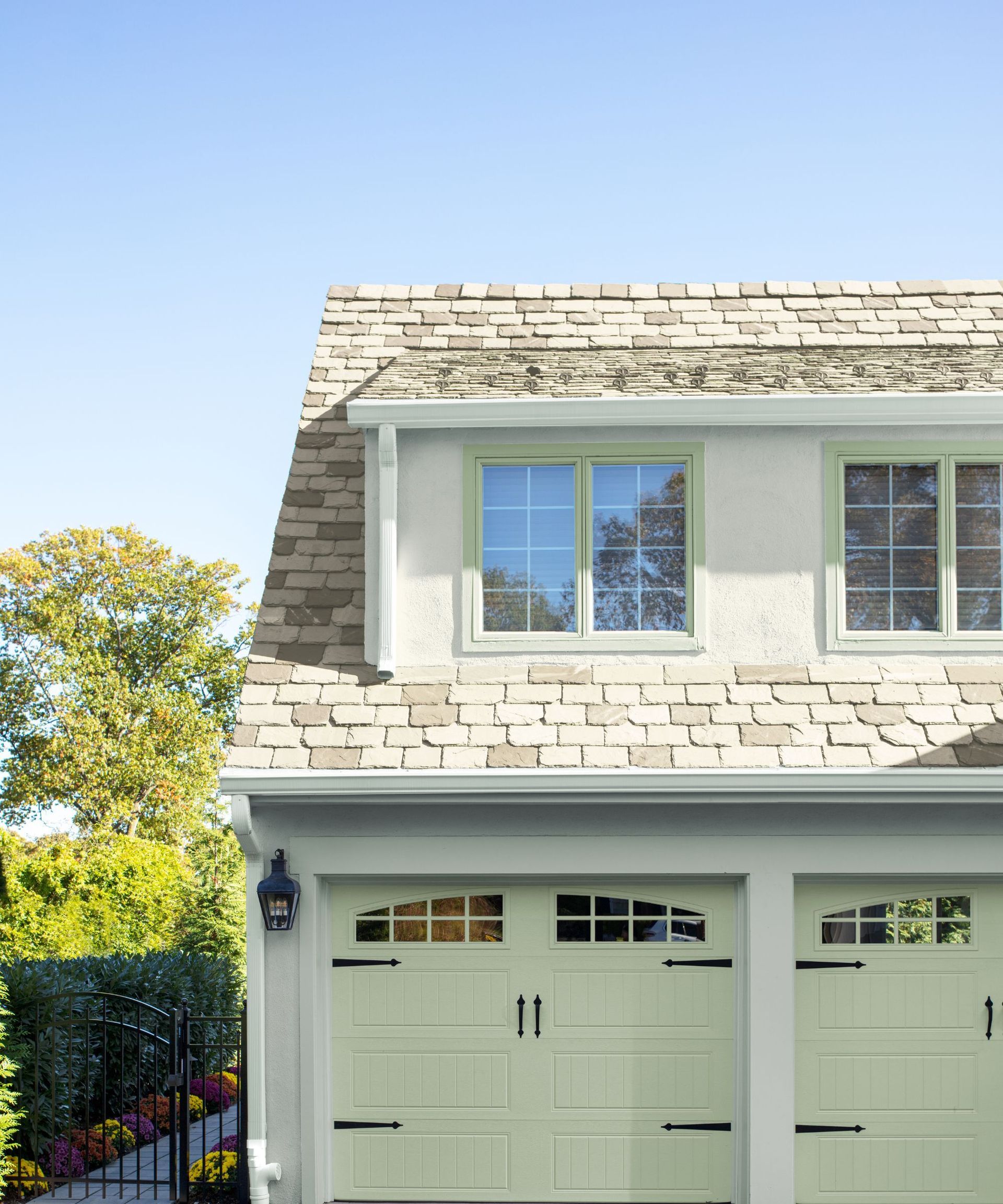The exterior of a house with light green garage doors