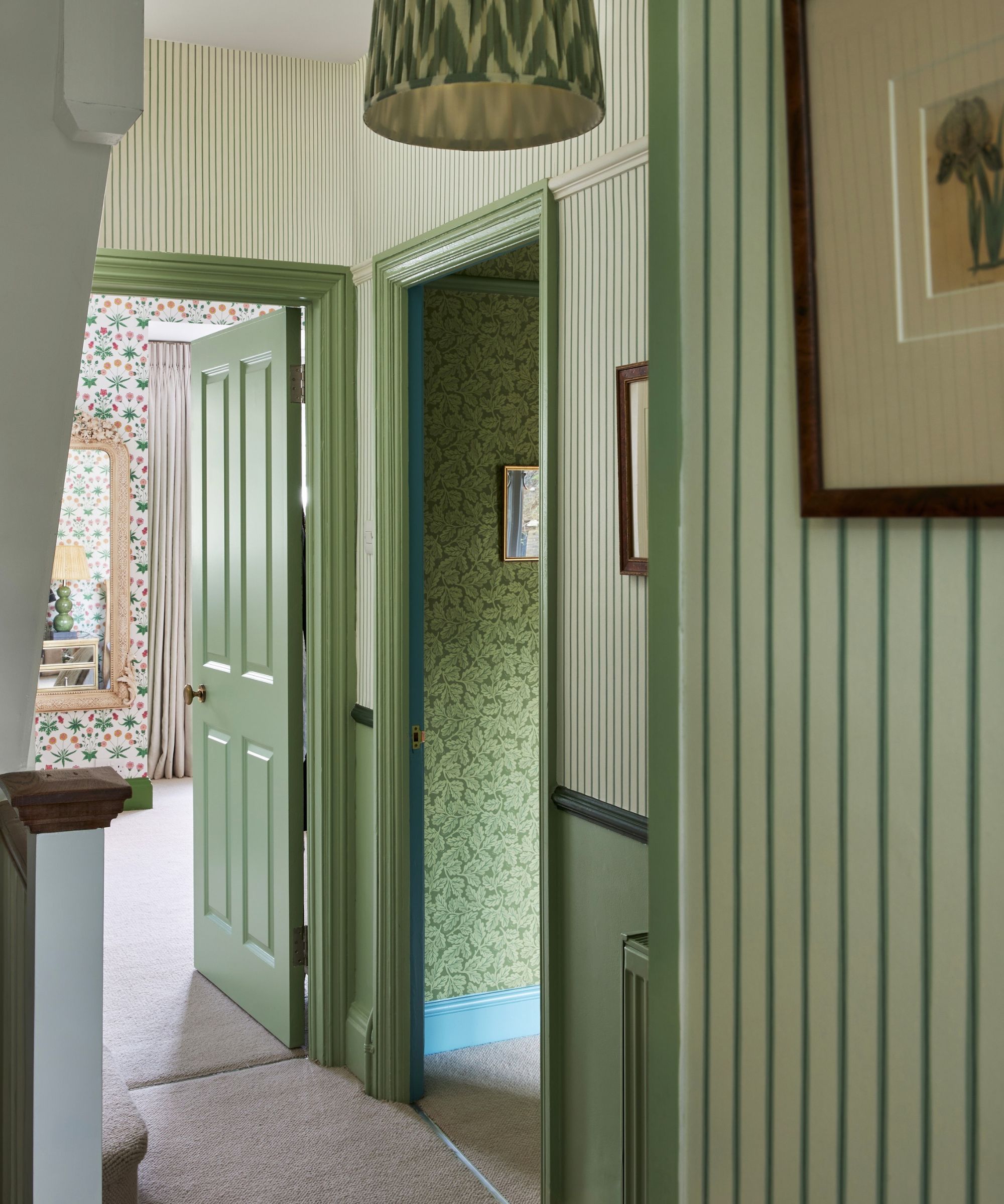 hallway with green striped wallpaper and green painted woodwork trim