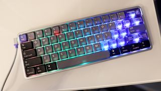 NuPhy Air60 HE gaming keyboard on a desk with RGB enabled.