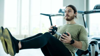 Man doing ab workout with dumbbell