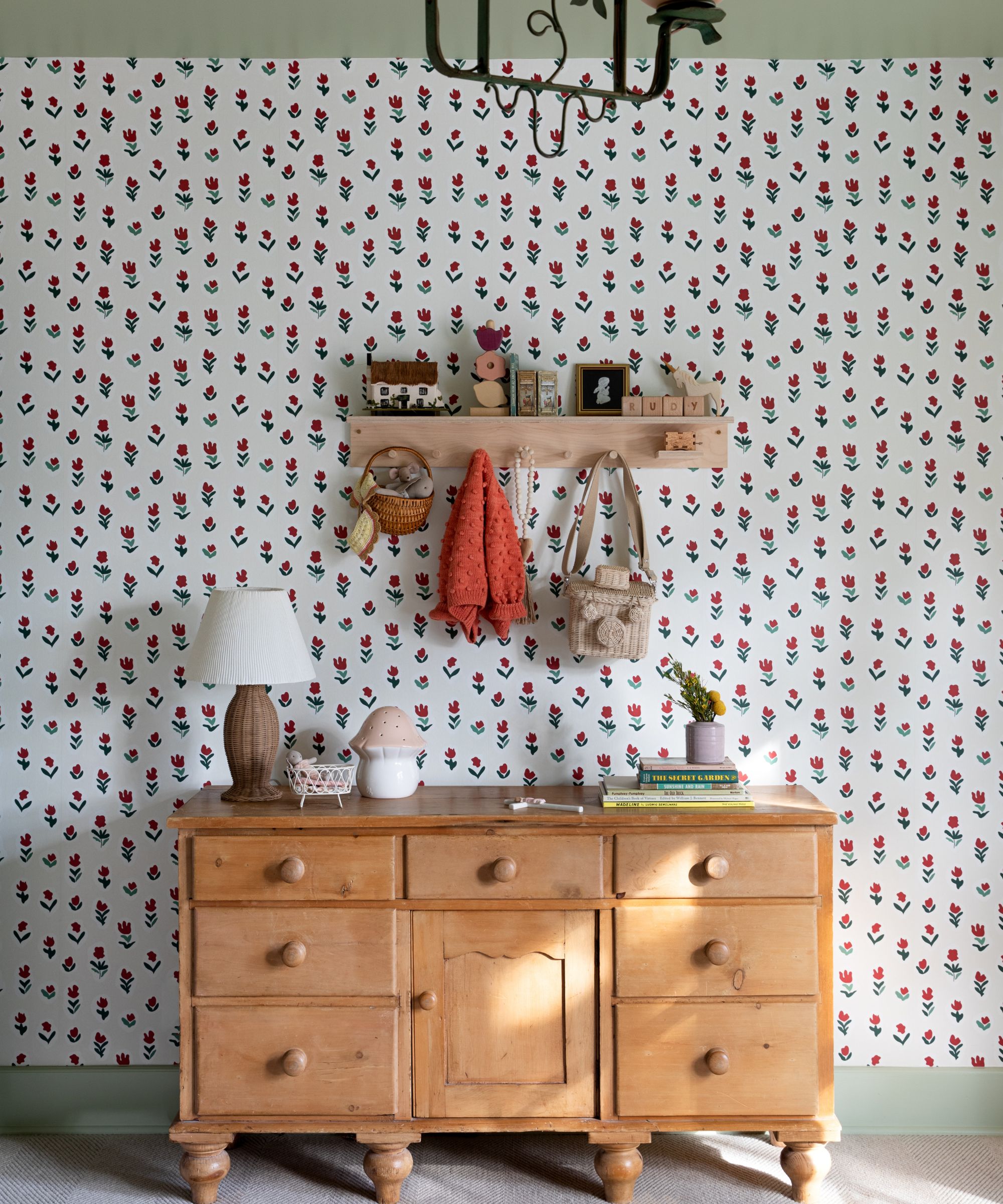 childrens bedroom with tulip wallpaper and a small chest of drawers