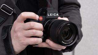 Mains tenant l'appareil photo Leica SL3