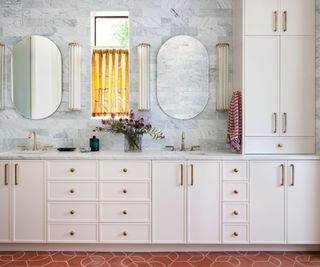 bathroom with white built in cabinetry and double sinks with mirrors