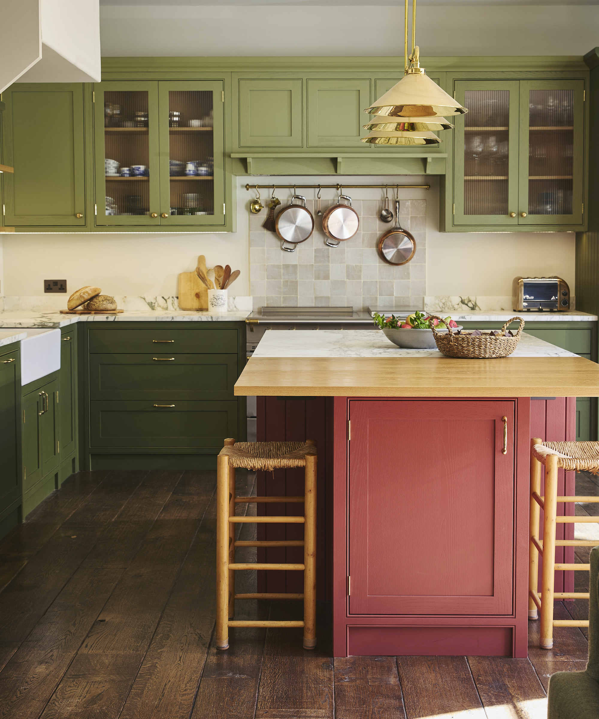 kitchen with dark pink island and green cabinets