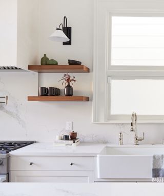 things that make a kitchen look cheap/white kitchen with marble countertops, dark wood open shelving, nickel fixtures and fittings