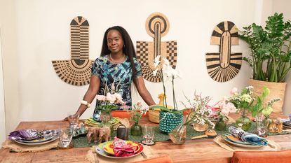 Eva Sonaike in her home by a table set up for a dinner party 