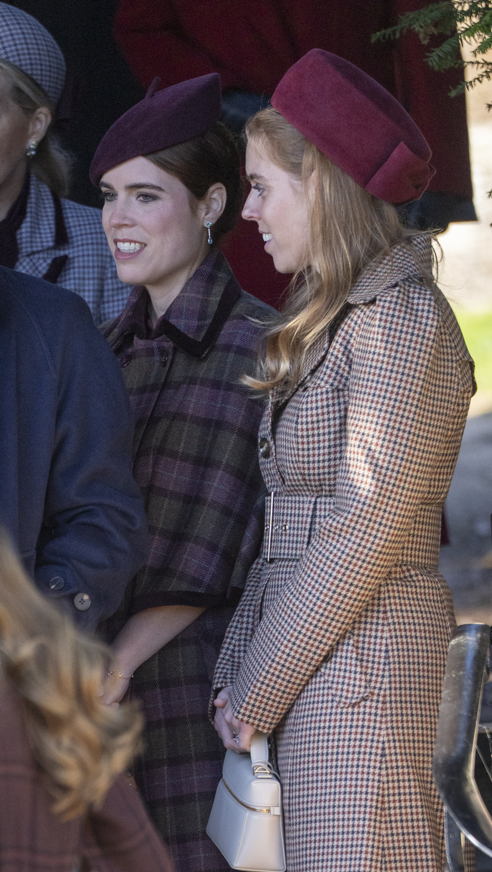 Princess Eugenie and Princess Beatrice wearing hats and plaid coats