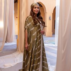 Sheikha Bodour wearing a green caftan in front of curtains