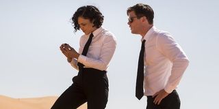 Tessa Thompson and Chris Hemsworth examine an item in the desert in Men In Black International