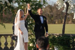 Taylor Krause and Garrett Hoseman raise their clasped hands after getting married, in episode 712 of Love Is Blind.