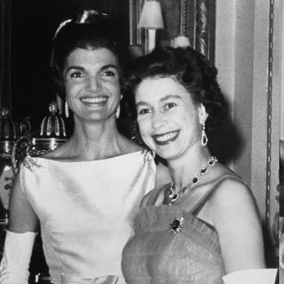 Jackie Kennedy and Queen Elizabeth dressed in formal wear at a Buckingham Palace dinner in 1961