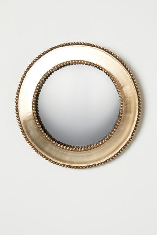 A convex mirror with a gold frame