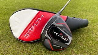 The TaylorMade Stealth 2 Fairway wood resting on the golf course with its club head cover