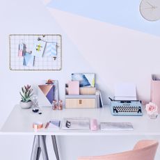 room with blue and white wall and desk with typing machine and armchair