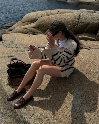 Woman wearing a striped sweater and Miu Miu boat shoes.